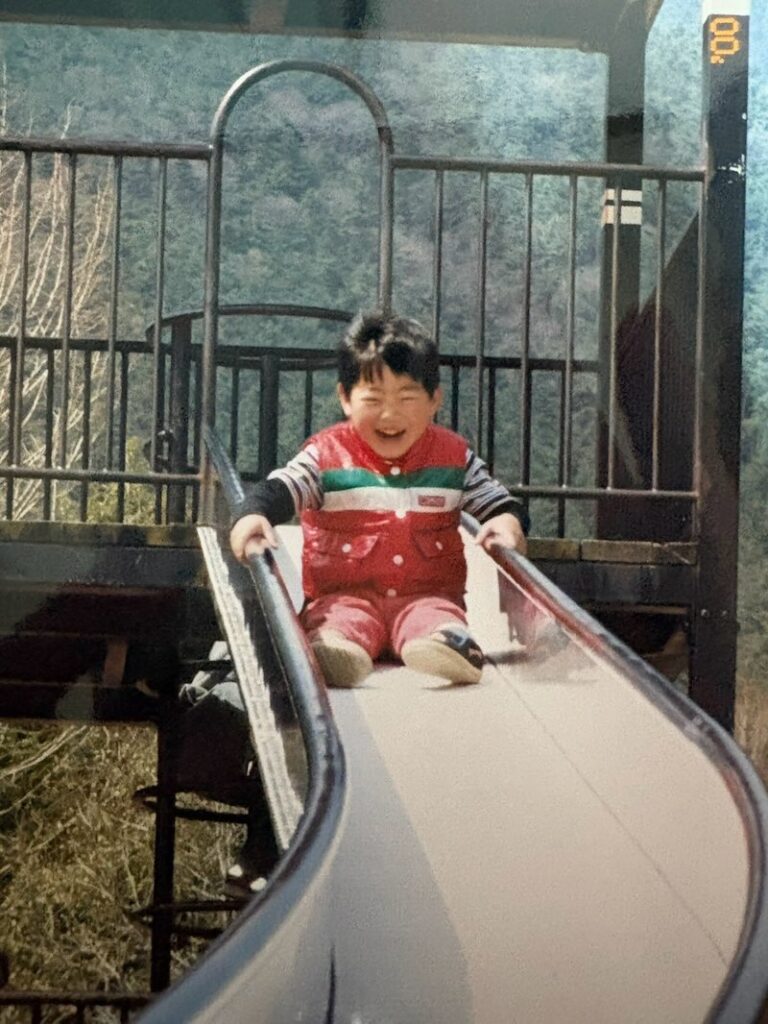 院長の中西秀章の幼少期の滑り台で滑っている写真